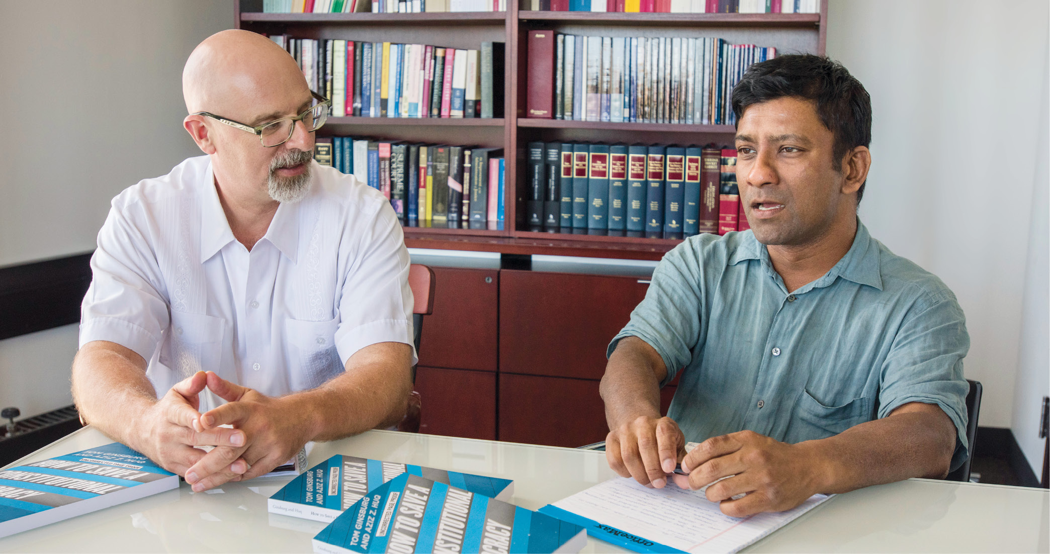 Professors Tom Ginsburg and Aziz Huq with their book, "How to Save a Constitutional Democracy"