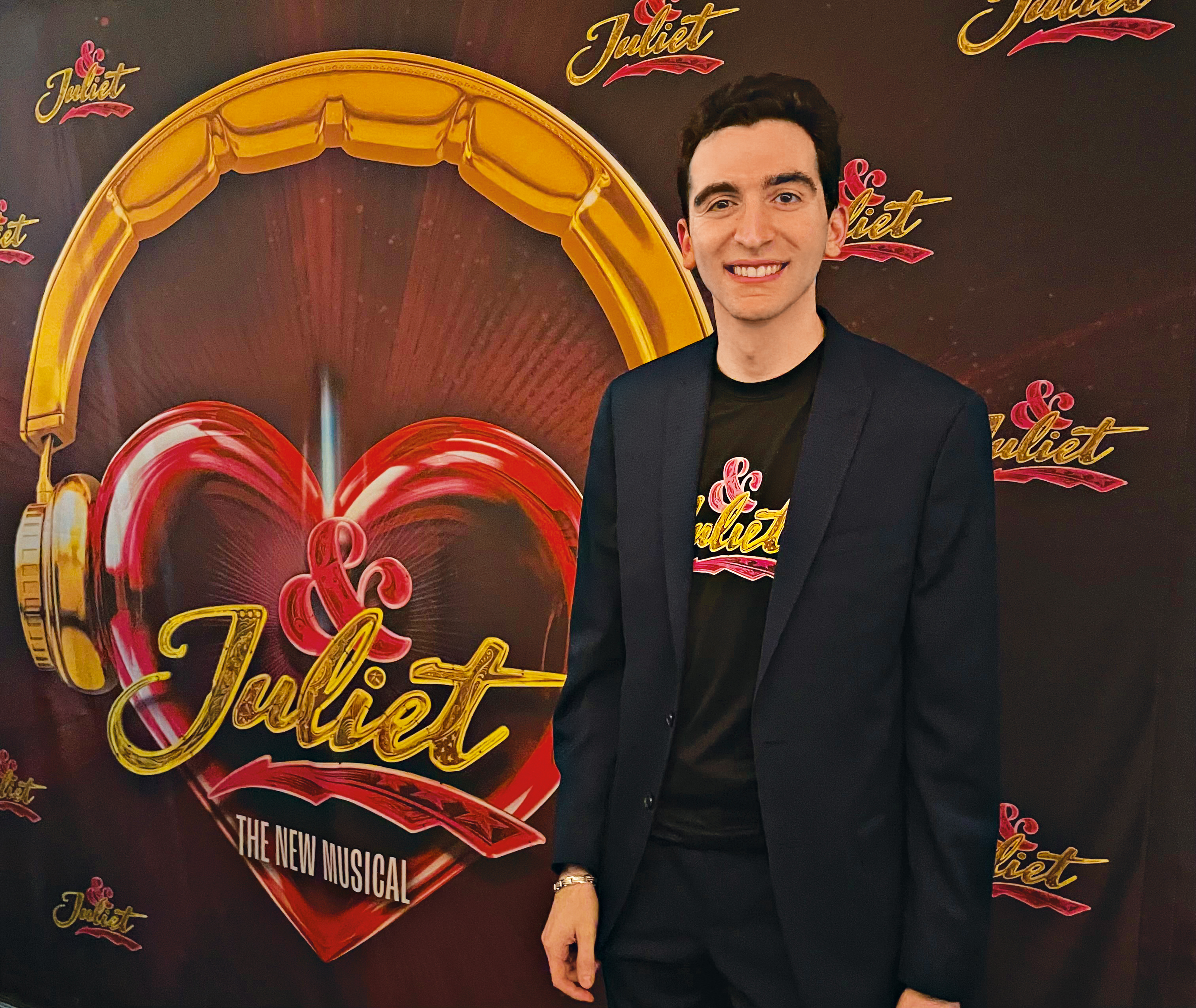 A person standing in front of a sign that has "Juliet, The New Musical" on it