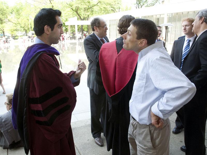 Professor Adam Samaha talks with a student after graduation in 2009. 