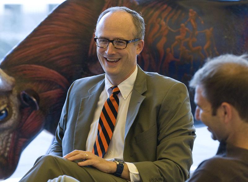 Assistant Professor M. Todd Henderson chats with students in the Green Lounge.