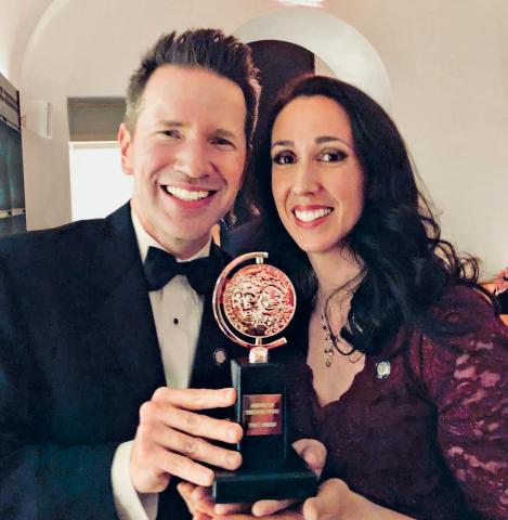 Two people holding an award