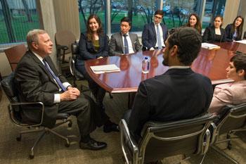 Senator Durbin and clinic students sit around a confererence table in the Kane Center