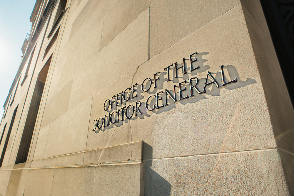 Outside the DOJ building. Lettering reads: Office of the Solicitor General