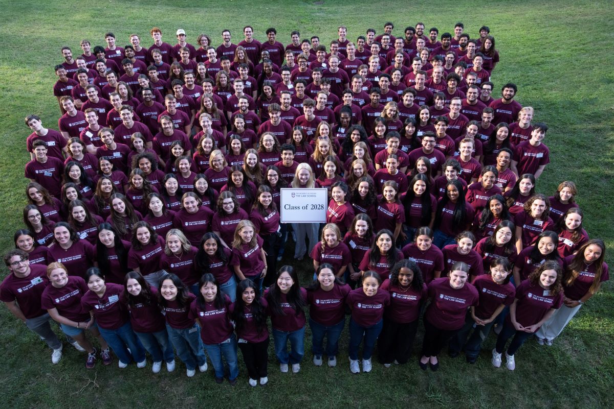 An aerial shot of 200 students all wearing maroon shirts standing closely together posing for a photo