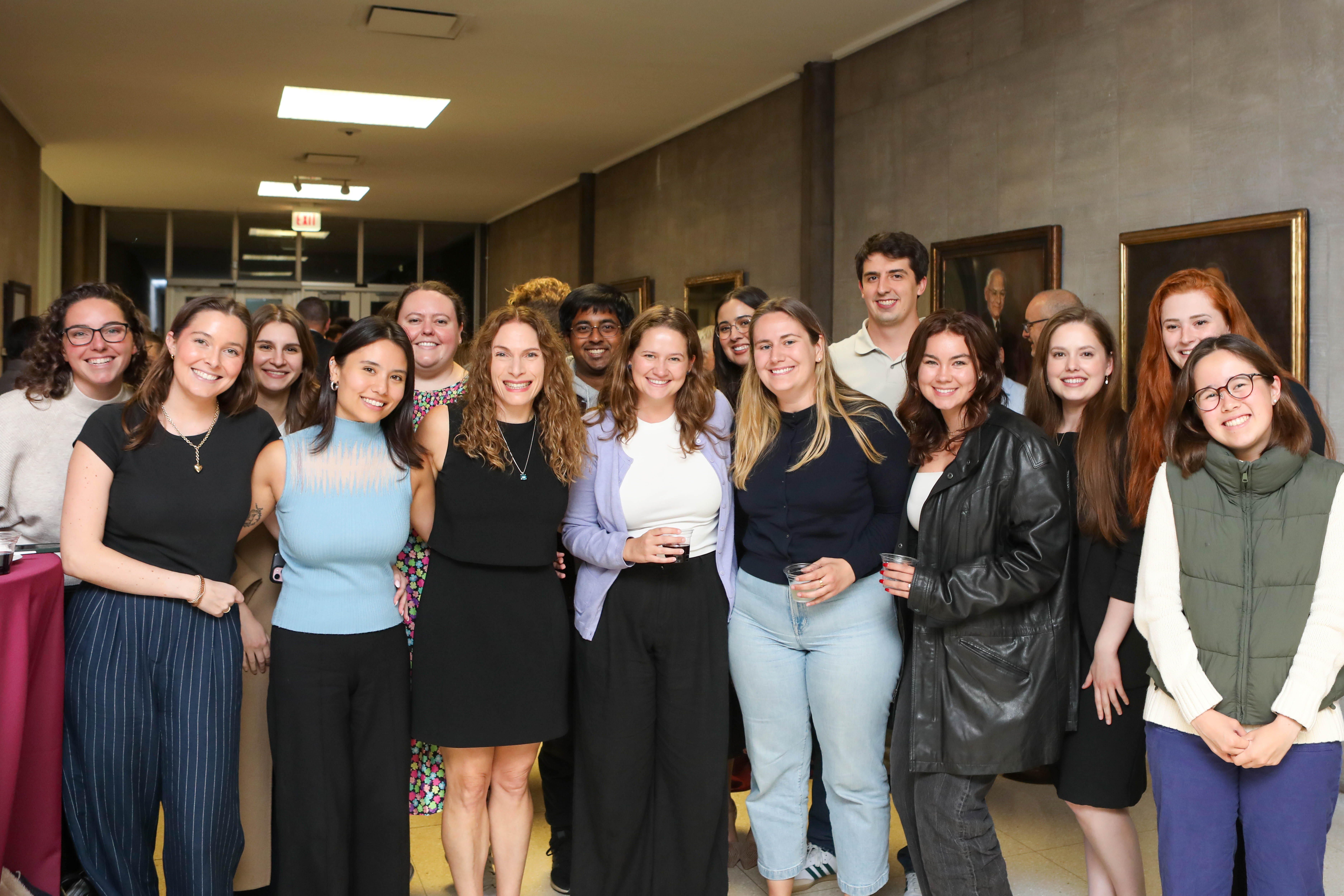A group of students, both men and women, stand side by side to pose for a group photo with Professor Siegler.