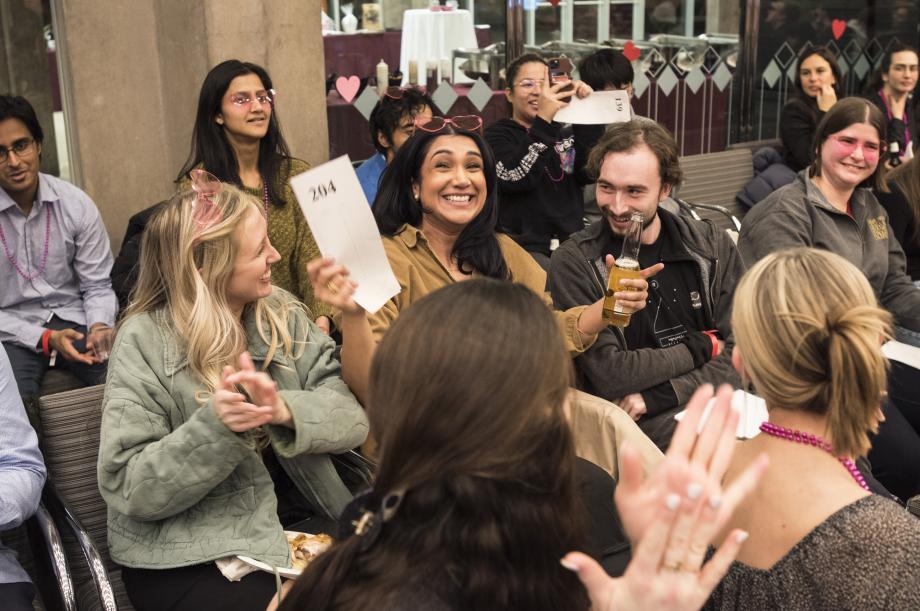 A student holds her bid card, grinning.