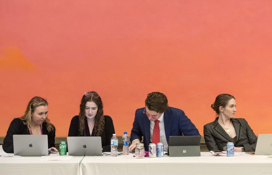 The CLF board sits in a row a table with their laptop screens open.