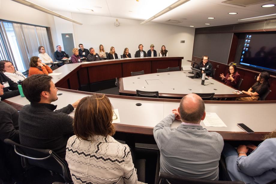 People sitting in a classroom with 3 presenters.