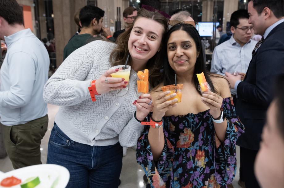 Two students holding popsicles and drinks.