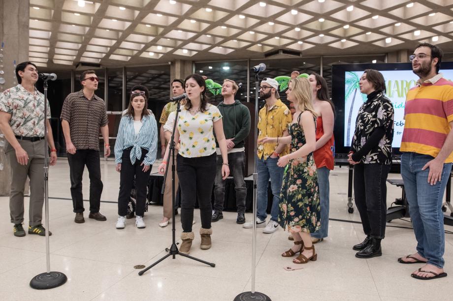 Twelve students singing with three microphones.