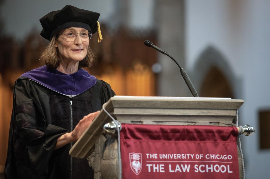 Lee Fennell stands in the front of the podium, speaking to the Class of 2023.