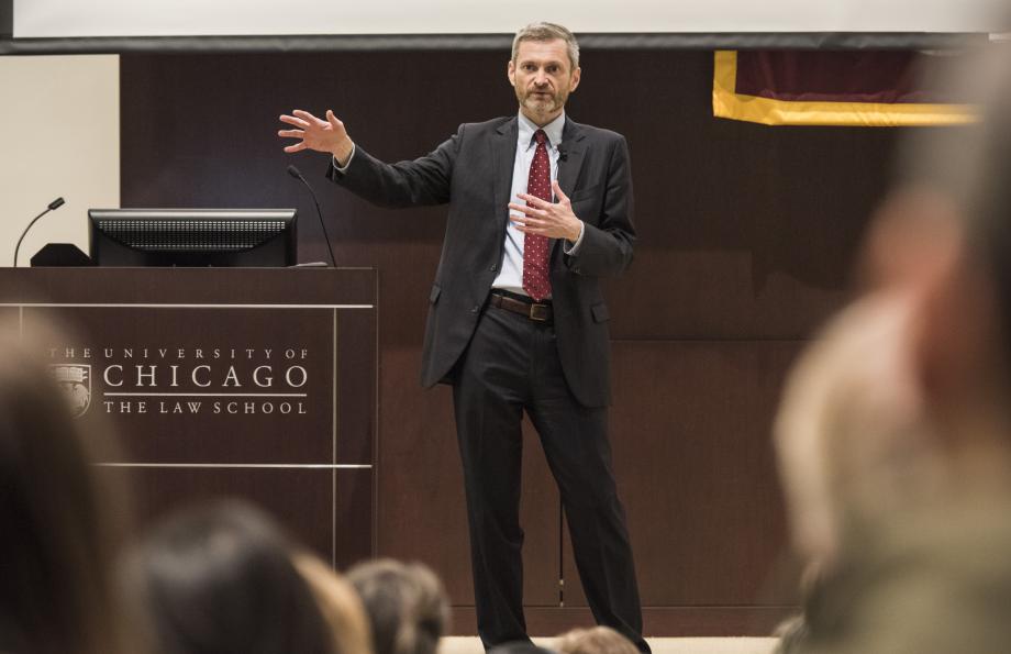 Tom Miles speaking at the front of the auditorium.