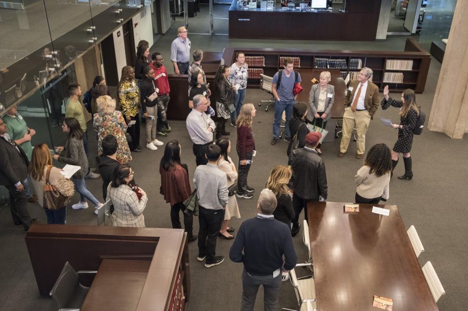 A shot from above of a group tour on the second floor of the law library.