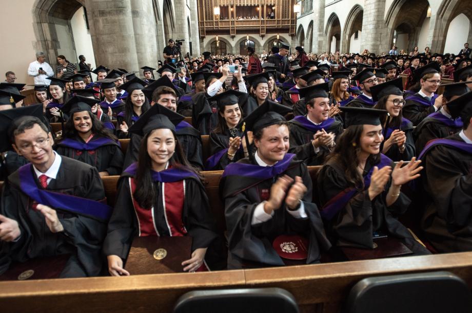 Students in the pews clap their hands.