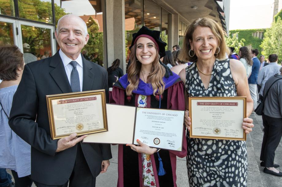 A family proudly displays their University of Chicago Law School diplomas.