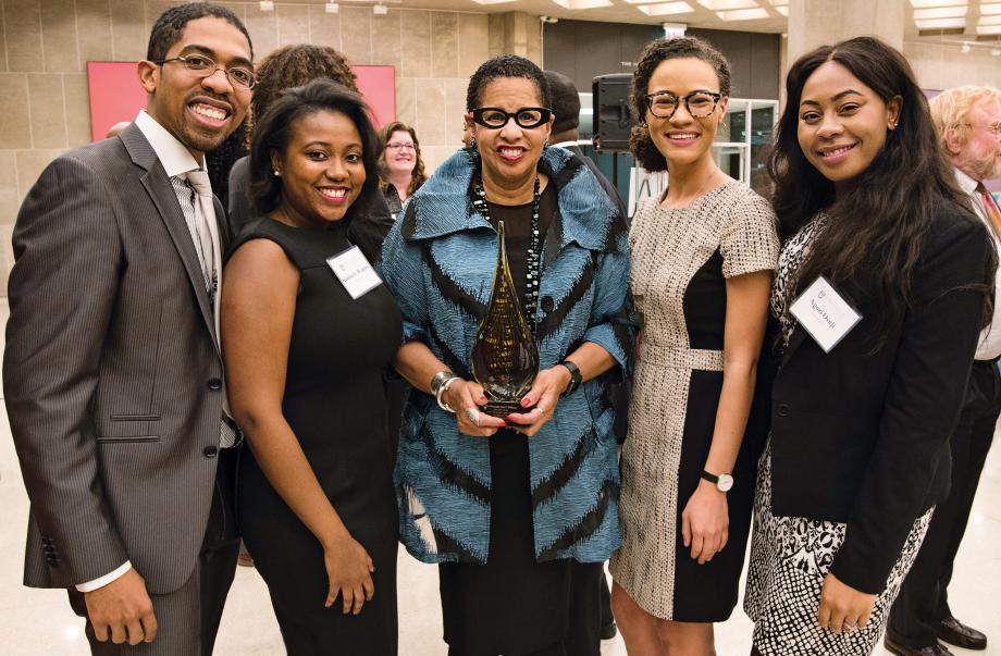 Judge Ann C. Williams, holding a trophy, and student organizers pose for the camera