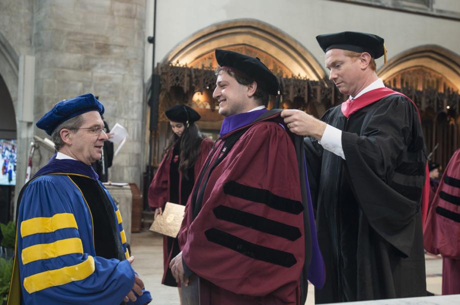 Faculty hooders Douglas Baird, Harry A. Bigelow Distinguished Service Professor of Law, and Jonathan Masur, John P. Wilson Professor of Law and David and Celia Hilliard Research Scholar, gave Julius Kairey, '18, his academic hood.