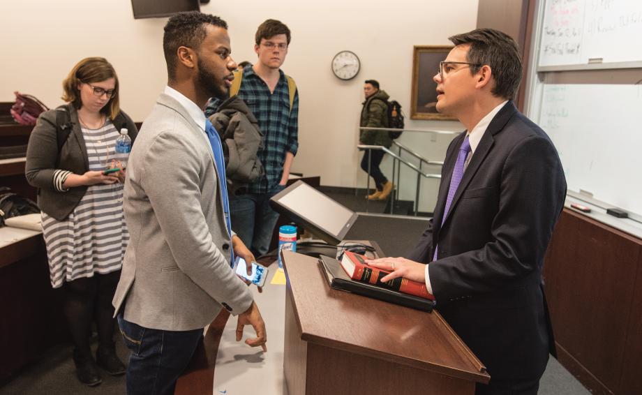 Adam Chilton speaking with a student