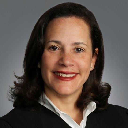 A photo of the Honorable Judge Sara Ellis, the lunch talk speaker. Judge Ellis is smiling, and wearing a black robe with a white collar.