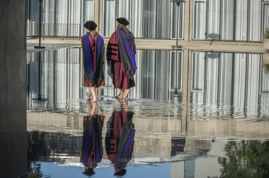 Two students walking in the reflecting pool.