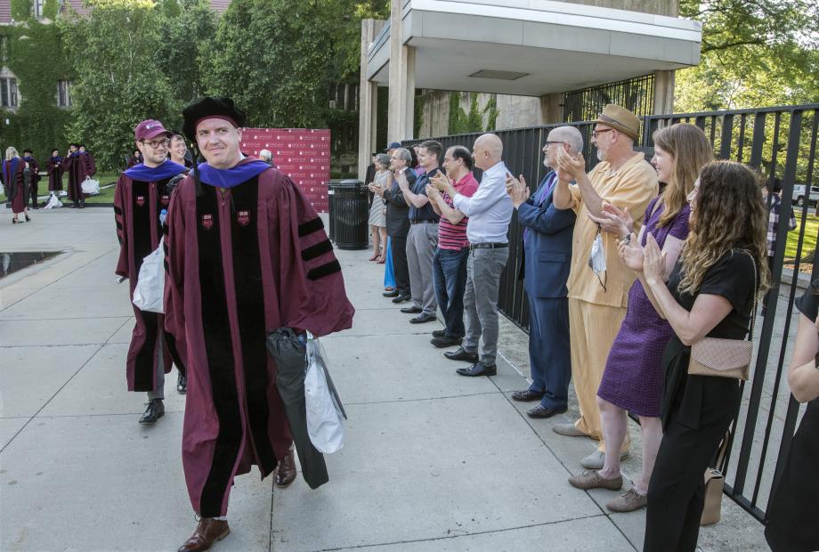 aculty lined up to cheer the new graduates beside the Levin Reflecting Pool.