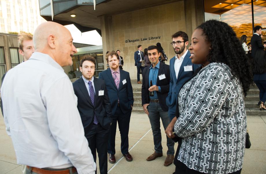 Students chat outside with Professor Omri Ben-Shahar.
