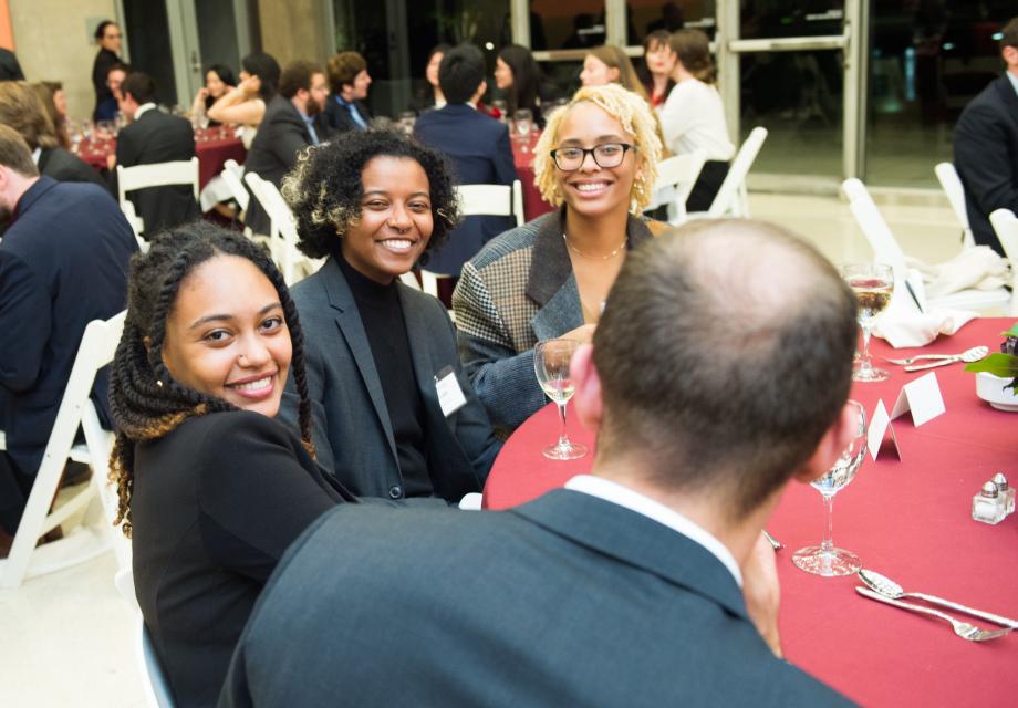 Several students smile for the camera at the Entering Students Dinner. 