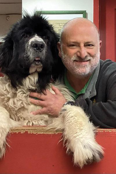 Mark Klaiman with a large black and white dog