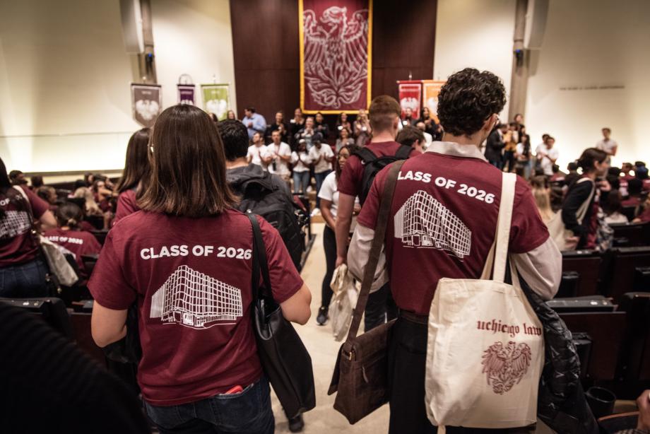 Students line the center aisle of the auditorium.