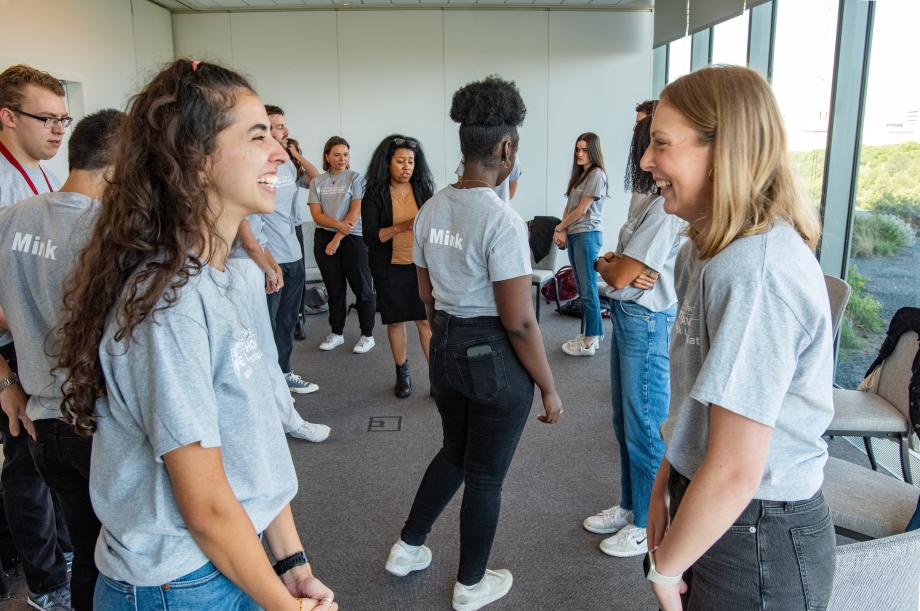 Two students face each other as they laugh.