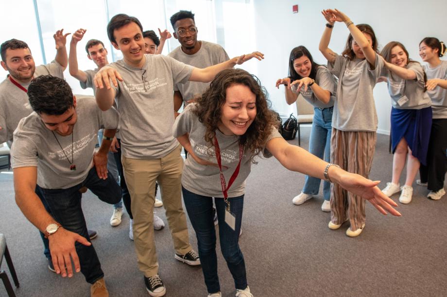 Several students hold their poses holding their arms up or out.