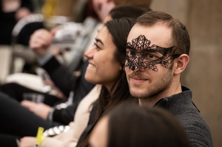 A close up of a man wearing a masquerade mask.