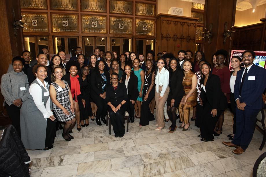 Sharon Johnson Coleman is seated in the middle of a group photo of more 40 students standing in a semi circle.