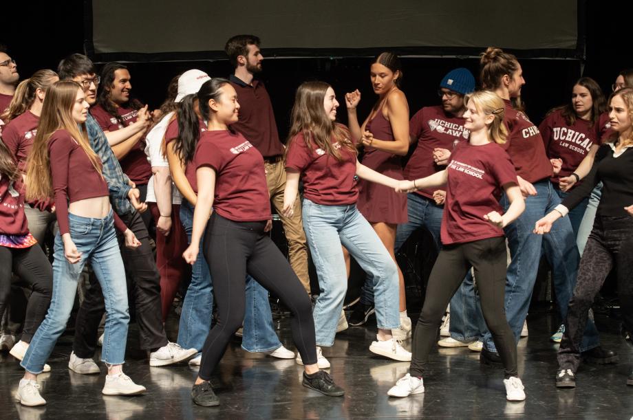 Students shimmy on stage in maroon shirts. 