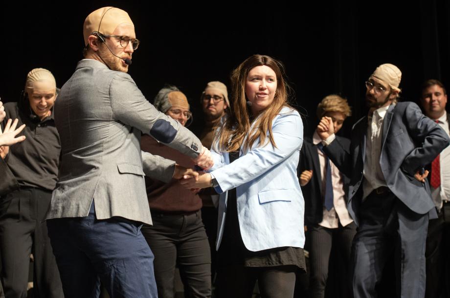 The students playing Professors Levmore and Robertson cross hands facing each other and look out to the audience.