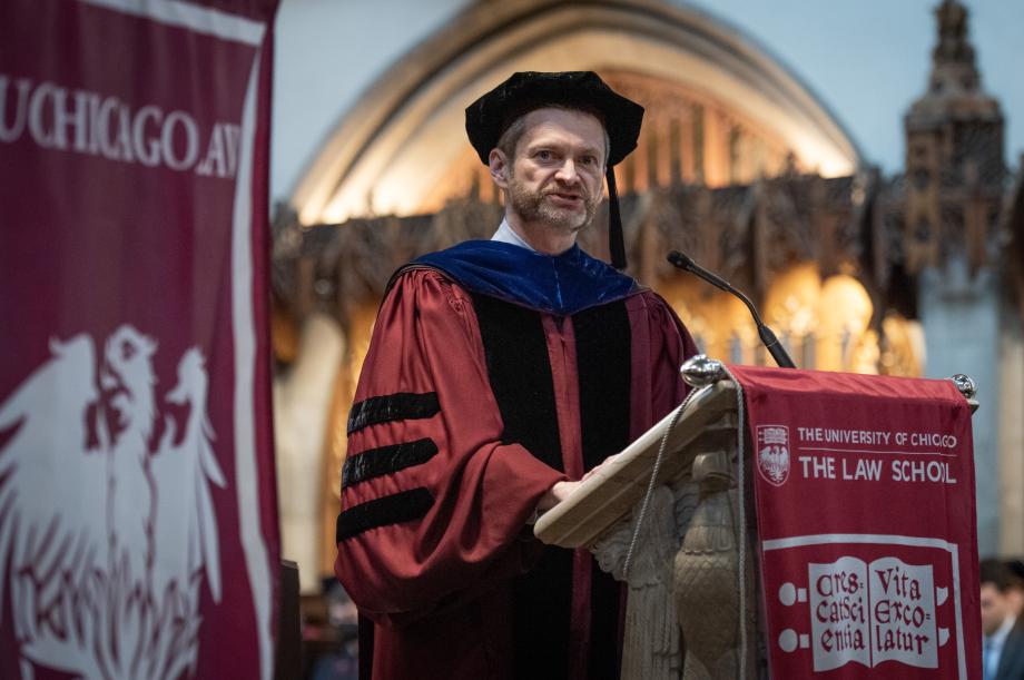 Thomas Miles, in a cap and gown, speaks from the podium.