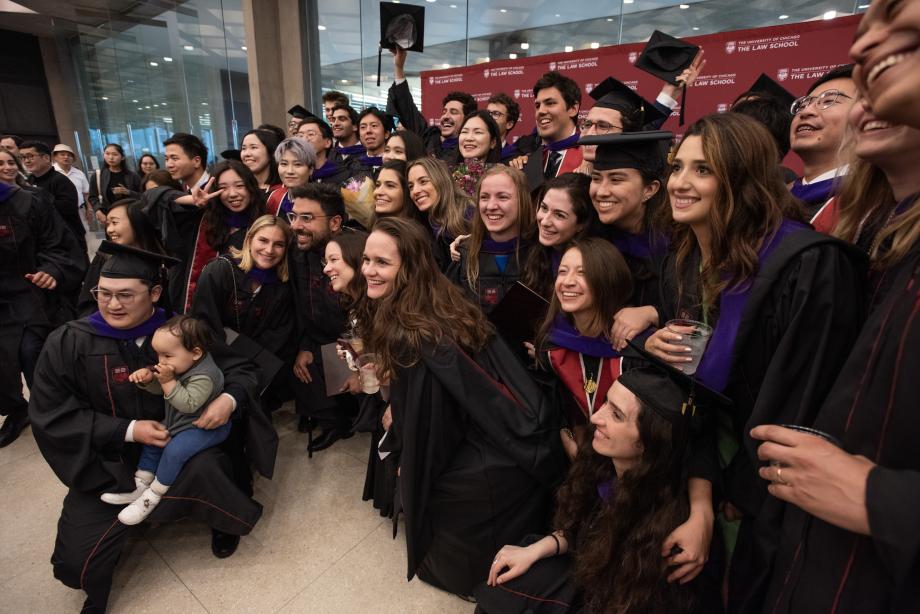Dozens of students pose for a group photo in front of a branded backdrop.