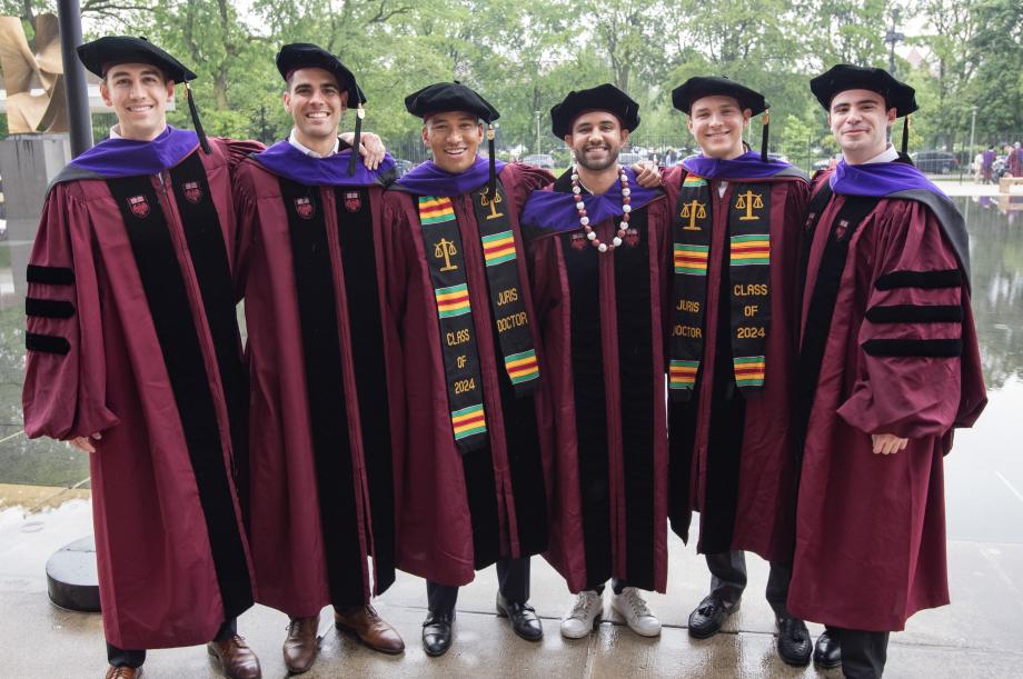 Five men in their caps and gowns smile for a posed photo.