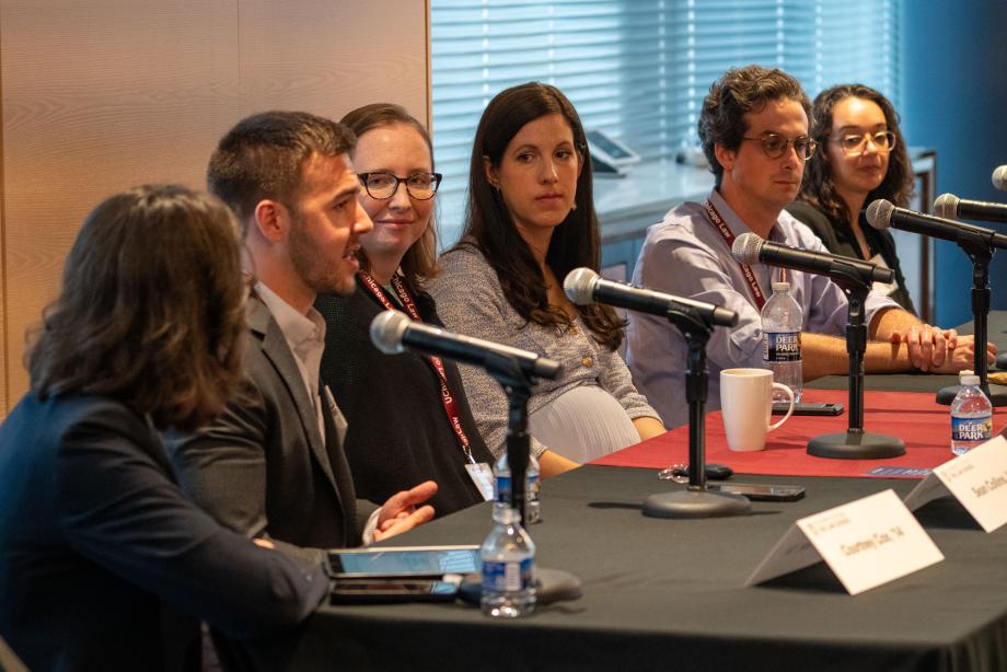 The Law Firms panel included moderator Courtney Cox, ’14; Sean Collins, ’15; Roisin Duffy-Gideon, ’18; Krista Perry Heckmann, ’16; Andrew Waks, ’19; and Caroline Wong, ’16. Five panelists sit a table draped with a University of Chicago Law School tablecloth. One panelist, in a beige suit jacket speaks into the tabletop microphone while the other panelists look on.