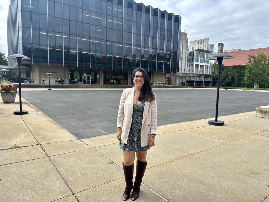 A woman stands in front of the Law School building.