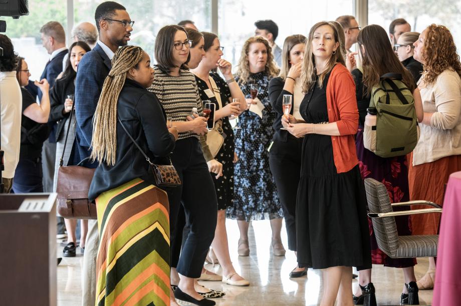 A room filled with people standing around and mingling.