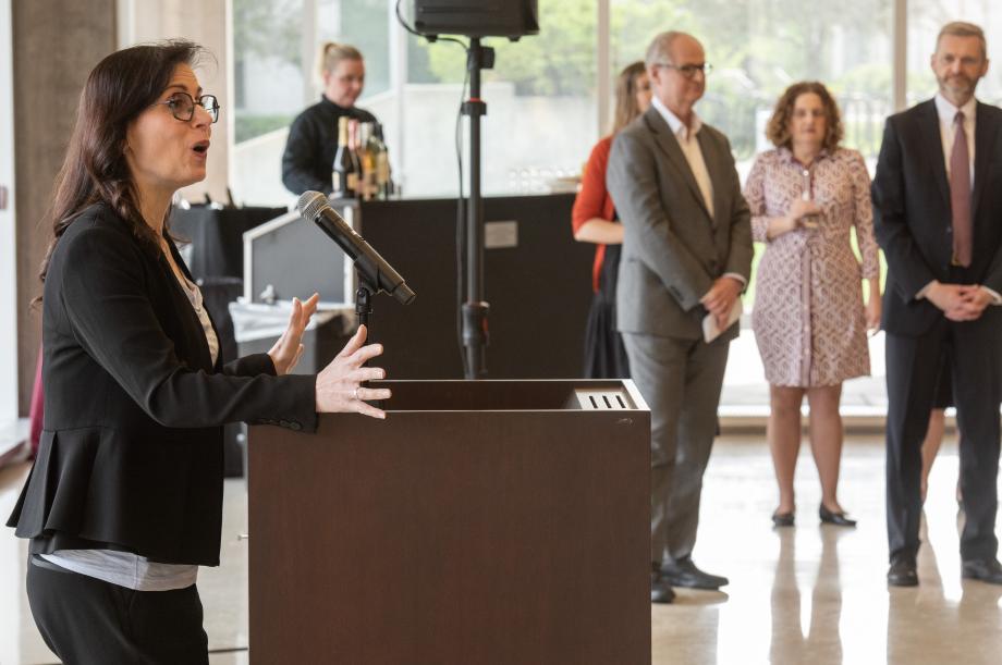 Provost Katherine Baicker stands at a lectern giving a speech