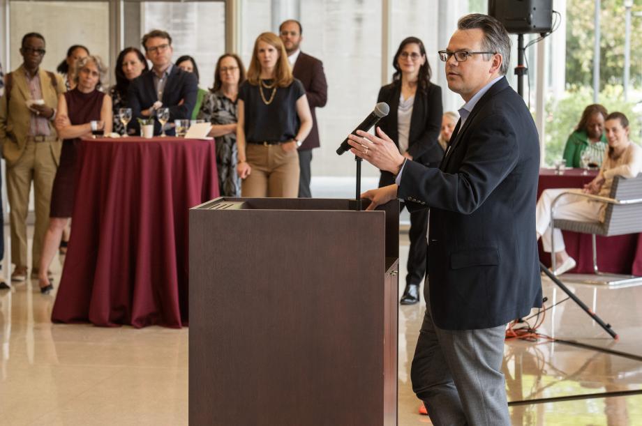 Adam Chilton stands at a lectern delivering a speech