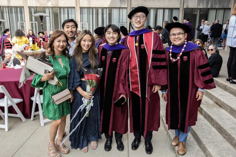 ...and take more photos with family and friends. A group of graduates pose for a photo.