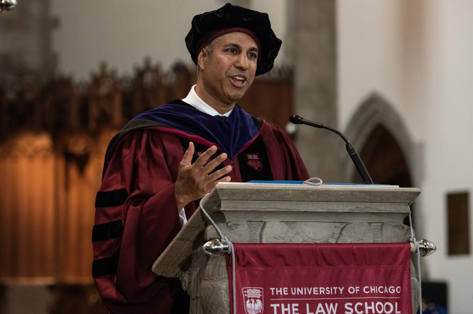 A man in cap and gown stands behind the podium.