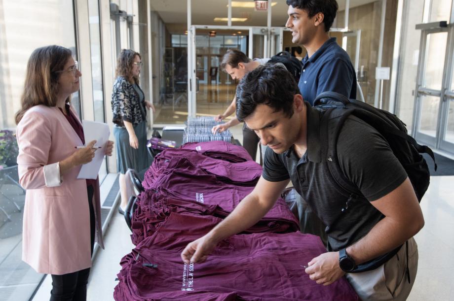 Students at a check-in table grabbing a t-shirt
