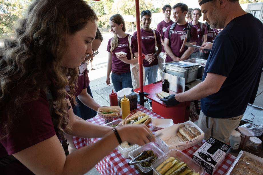 A student prepares a hotdog to eat.