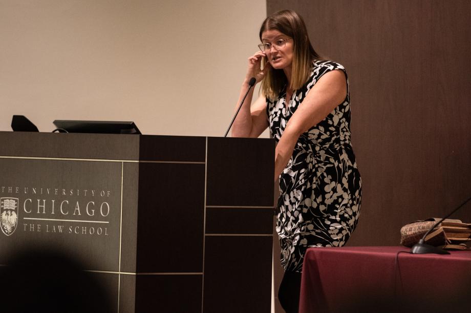 A woman stands at a lectern.