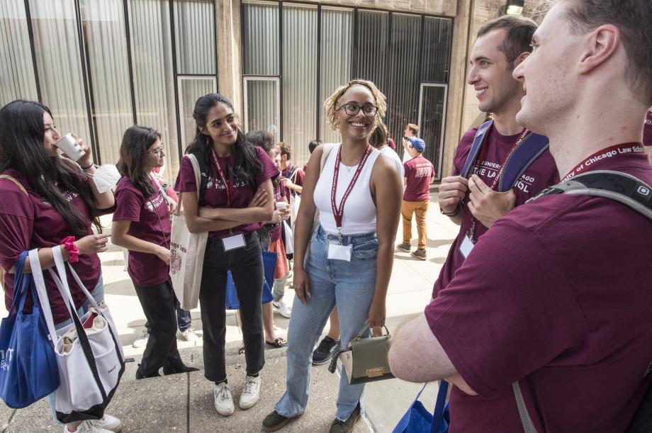 Students gather outside by the Reflecting Pool with the classroom wing visible in the background.