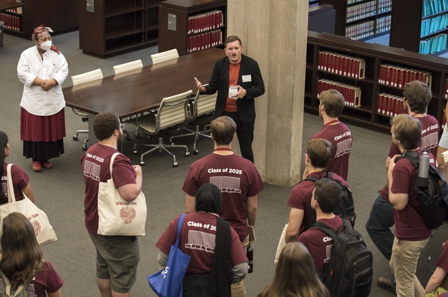 Two librarians speak to a group of students on the main floor of the D'Angelo Law Library. 